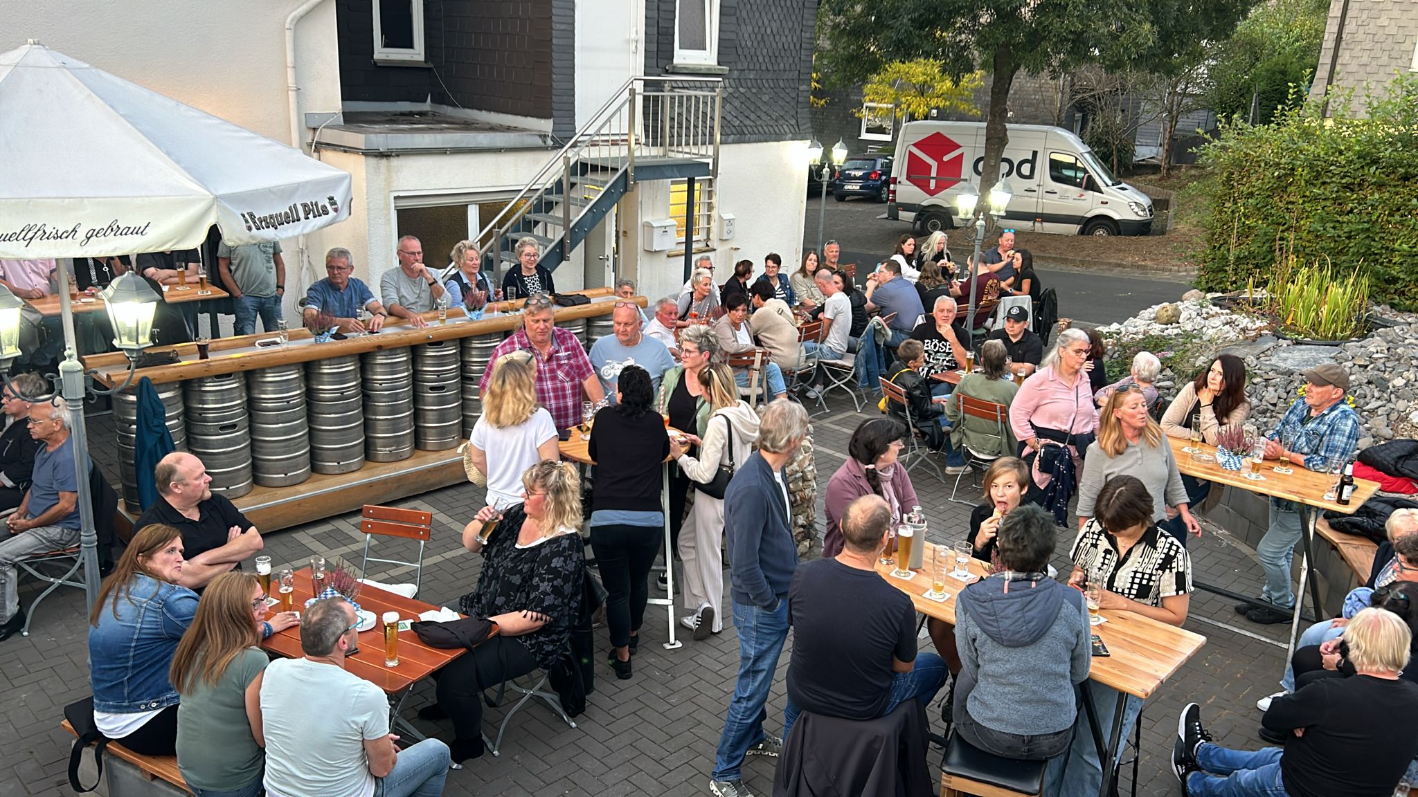 Gäste an den Tischen im Biergarten des Christians